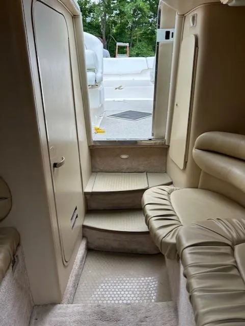 Slide: The Image of Interior of 1998 Sea Ray 28 CC boat with beige seating and steps leading outside. - 17