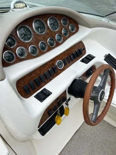Slide: The Image of Dashboard of a 1998 Sea Ray 28 CC boat with gauges and wooden steering wheel. - 19