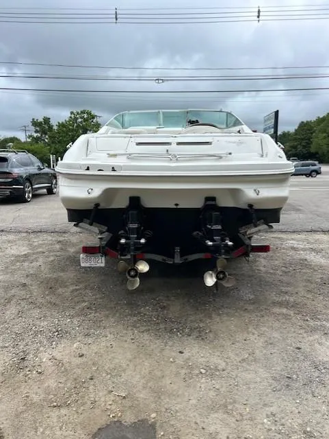 Slide: The Image of 1998 Sea Ray 28 CC boat, rear view, dual propellers, parked on gravel lot. - 2