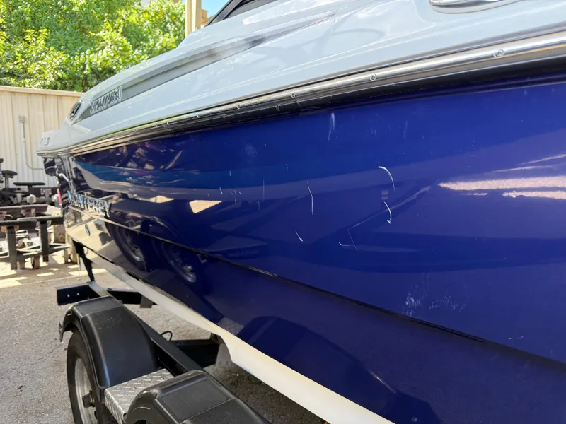 Slide: The Image of 2016 Monterey 196MS boat with blue hull and visible scratches, parked on a trailer. - 6