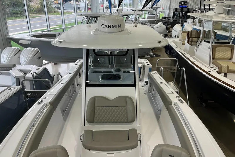 Slide: The Image of 2025 Sportsman Open 282 Center Console boat in showroom, featuring Garmin equipment. - 10