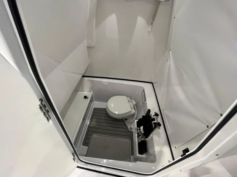 Slide: The Image of 2025 Sportsman Open 282 Center Console boat interior with compact marine toilet. - 22