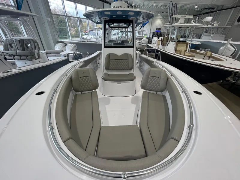 Slide: The Image of 2025 Sportsman Open 282 Center Console boat interior with cushioned seating in showroom. - 9