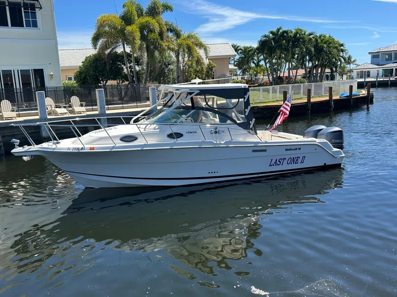 The Image of 2015 Wellcraft 290 Coastal boat docked in sunny marina with palm trees. - 0