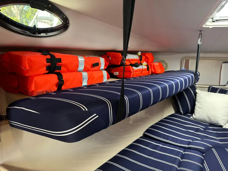 Slide: The Image of Interior of 2015 Wellcraft 290 Coastal boat with striped cushions and orange life jackets. - 12