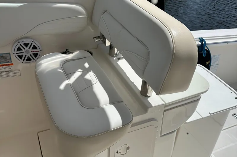 Slide: The Image of 2015 Wellcraft 290 Coastal boat seat with white upholstery and speaker detail. - 2