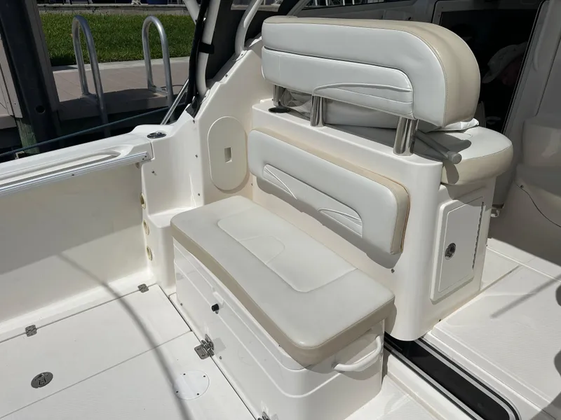 Slide: The Image of 2015 Wellcraft 290 Coastal boat interior with white cushioned seating and storage. - 3