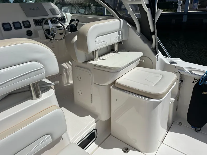 Slide: The Image of 2015 Wellcraft 290 Coastal boat interior with white seating and helm station. - 4