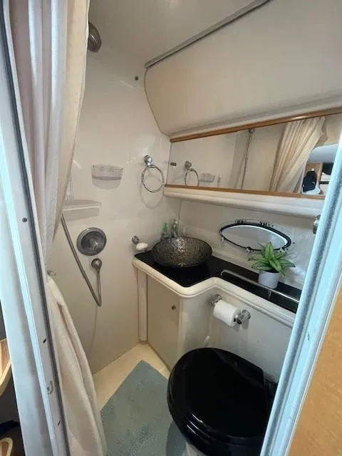 Slide: The Image of 2008 Larson Cabrio 330 Day Cruiser bathroom with sink, toilet, and shower. - 9