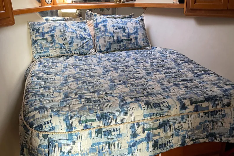 Slide: The Image of Cozy bedroom with blue-patterned bedding in 1996 Viking 47 Convertible yacht. - 12
