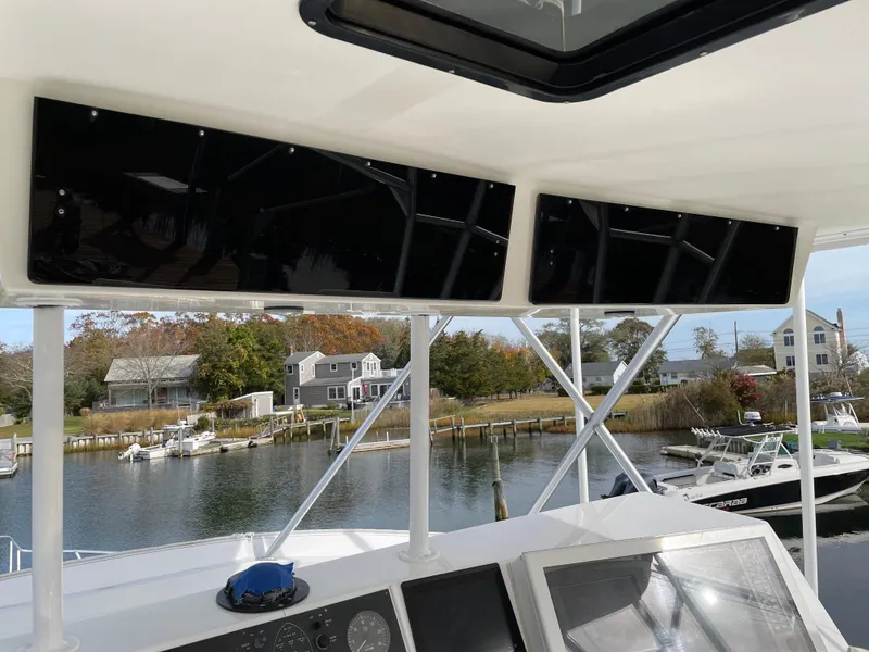 Slide: The Image of 1996 Viking 47 Convertible yacht helm with scenic waterfront view. - 17