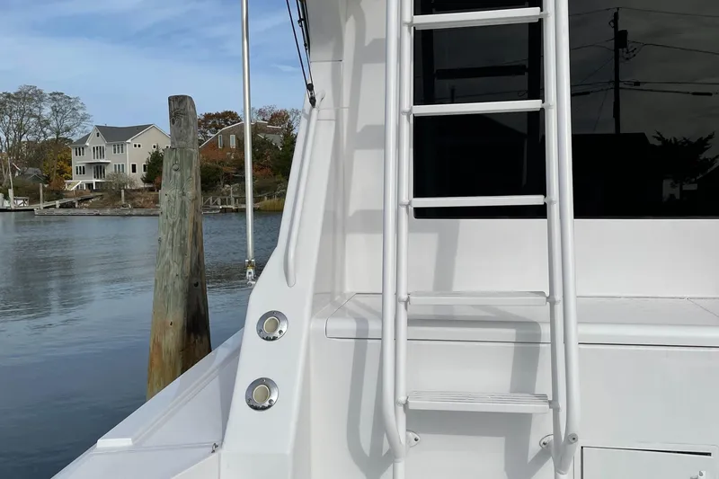 Slide: The Image of 1996 Viking 47 Convertible yacht docked by waterfront homes. - 22