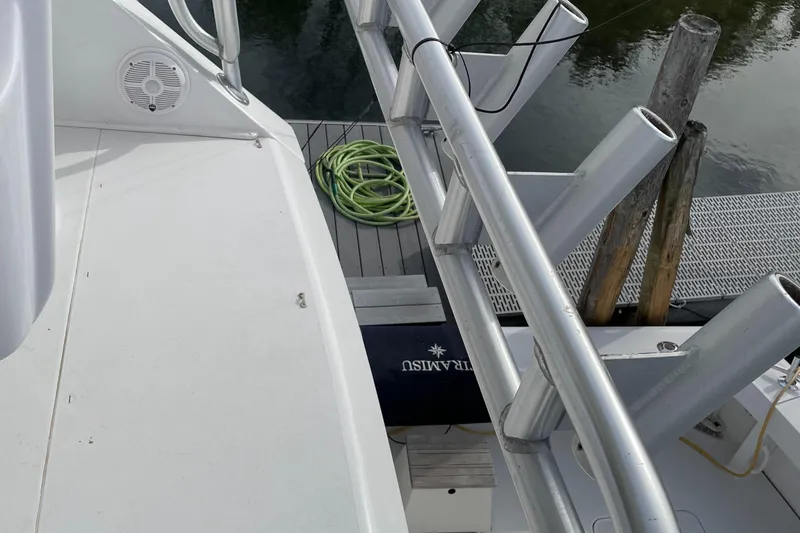Slide: The Image of 1996 Viking 47 Convertible yacht deck with fishing rod holders and dock view. - 24