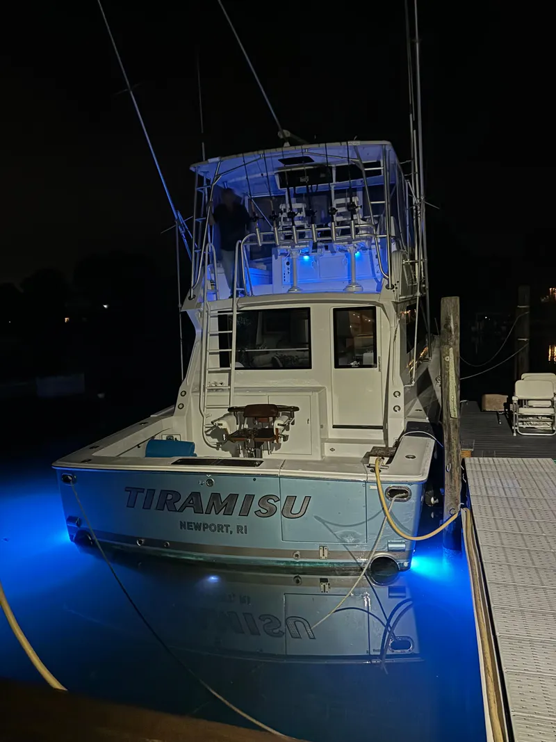 Slide: The Image of Viking 47 Convertible 1996 boat with blue underwater lights at night. - 36