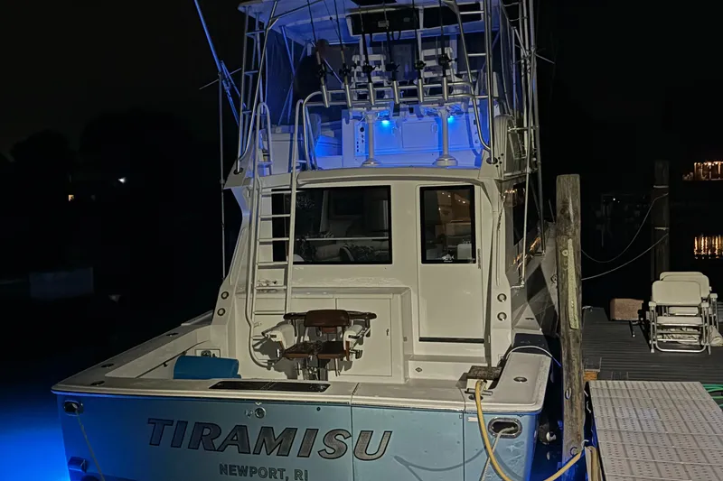 Slide: The Image of Viking 47 Convertible 1996 boat docked at night with blue lighting. - 37