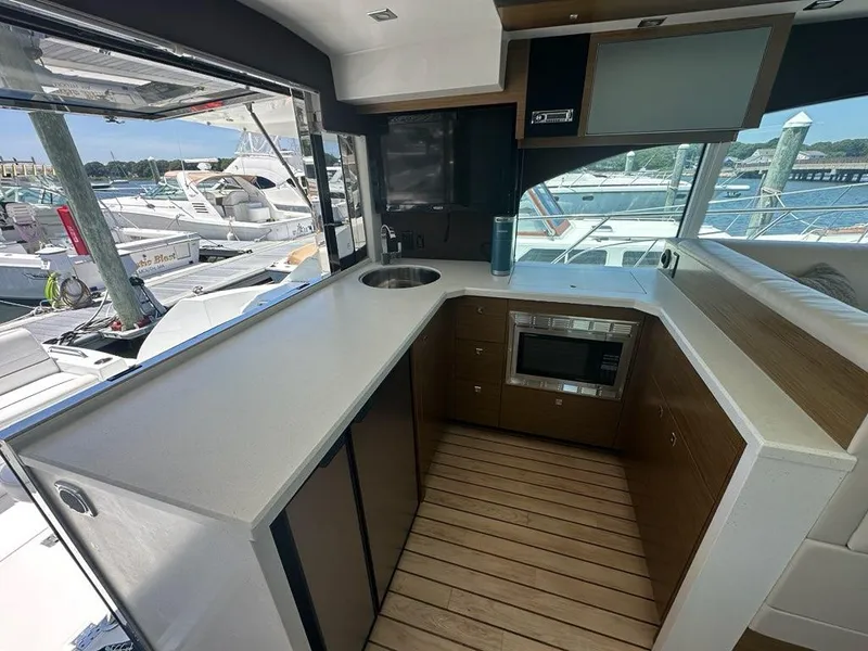 Slide: The Image of Interior of 2015 Cruisers Yachts 45 Cantius, featuring modern kitchen with marina view. - 28