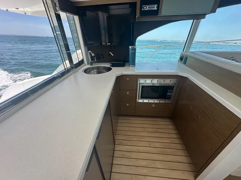 Slide: The Image of 2015 Cruisers Yachts 45 Cantius kitchen with ocean view, featuring modern appliances and sleek design. - 29