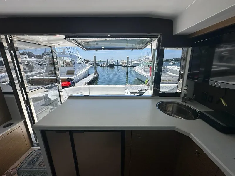 Slide: The Image of Interior view of 2015 Cruisers Yachts 45 Cantius, overlooking marina through open window. - 31