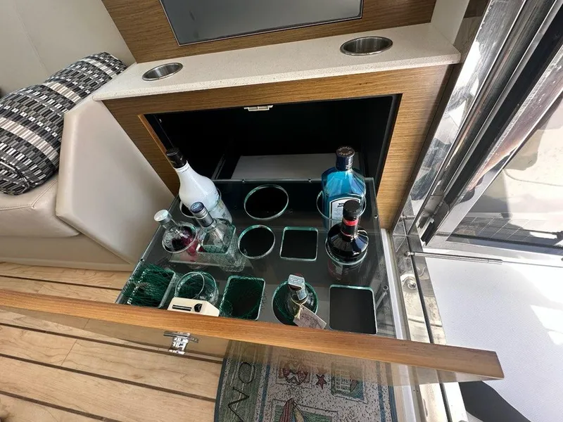 Slide: The Image of Bar area on 2015 Cruisers Yachts 45 Cantius with assorted bottles and glassware. - 33