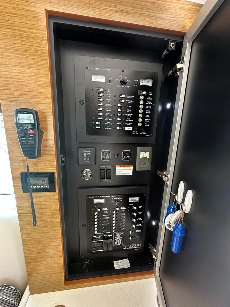 Slide: The Image of Electrical panel inside a 2015 Cruisers Yachts 45 Cantius, featuring switches and a radio. - 32