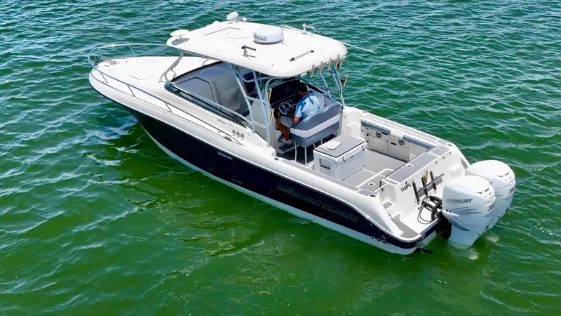 Slide: The Image of 2006 Hydra-Sports Vector VX boat on clear green water, featuring dual Mercury engines. - 10