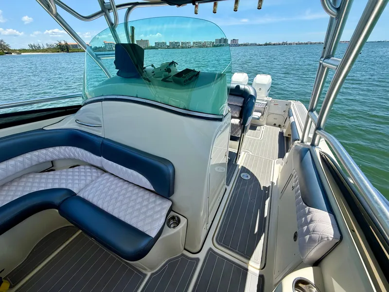 Slide: The Image of 2006 Hydra-Sports Vector VX boat interior with cushioned seating and helm, on calm water. - 21