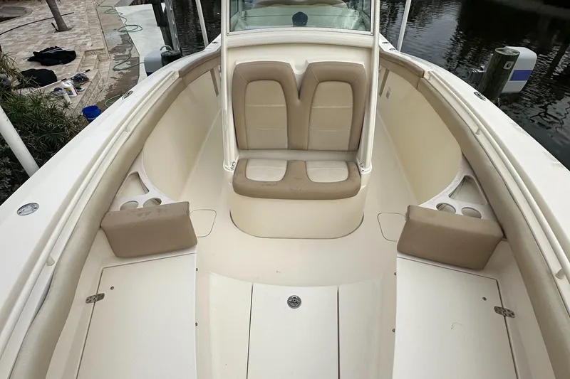 Slide: The Image of 2012 Scout 275 XSF boat interior with beige seating and cup holders. - 2