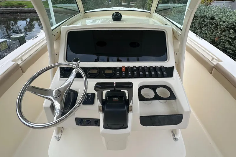 Slide: The Image of 2012 Scout 275 XSF boat dashboard with steering wheel and controls. - 4
