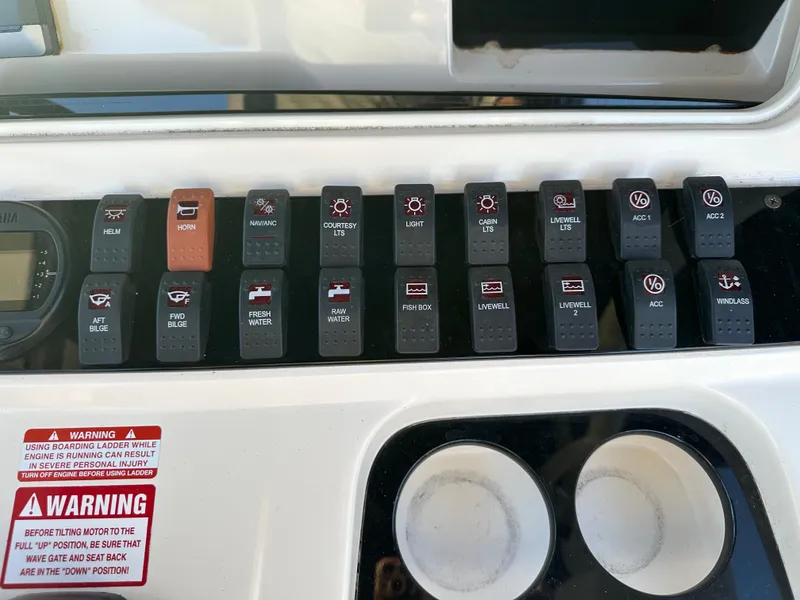 Slide: The Image of Control panel of a 2012 Scout 275 XSF boat with labeled switches and warning labels. - 8