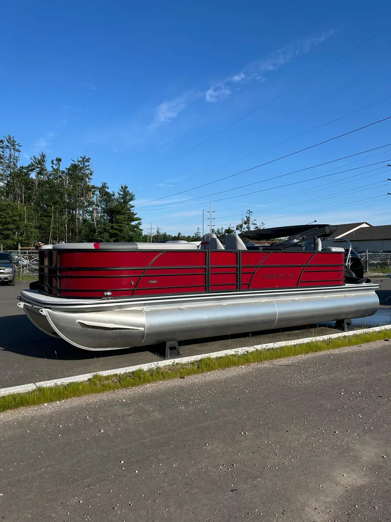 The Image of 2025 Trifecta 24ECS275 pontoon boat with red exterior, parked outdoors. - 0
