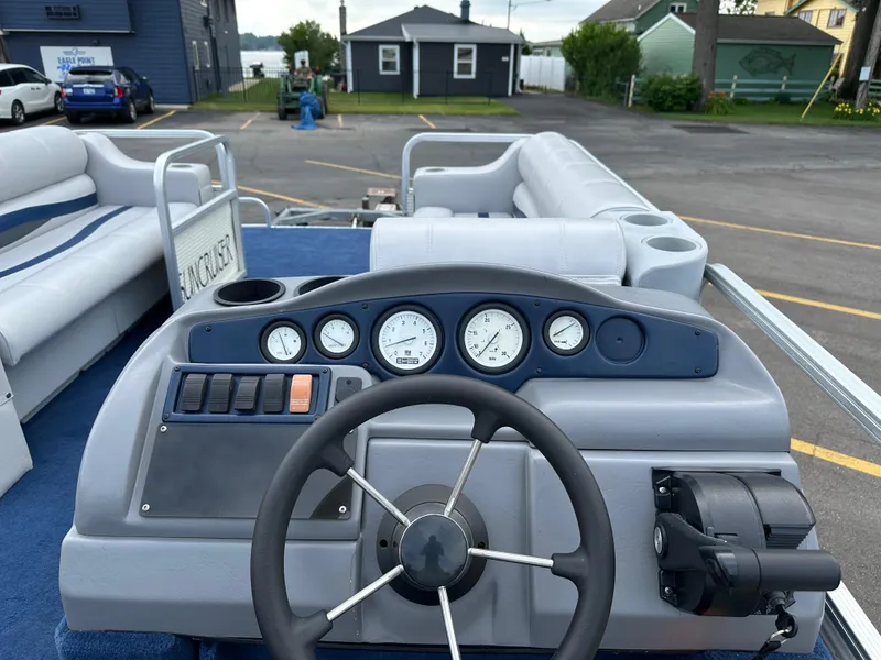 Slide: The Image of 1997 Suncruiser 22 boat dashboard with steering wheel and gauges, parked in a lot. - 11