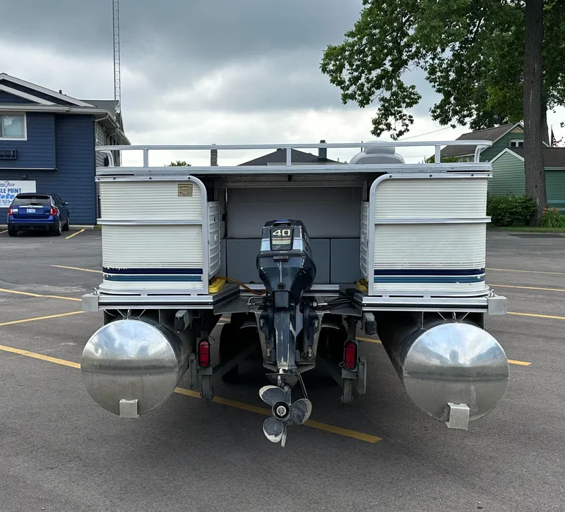 Slide: The Image of 1997 Suncruiser 22 pontoon boat with outboard motor in parking lot. - 5