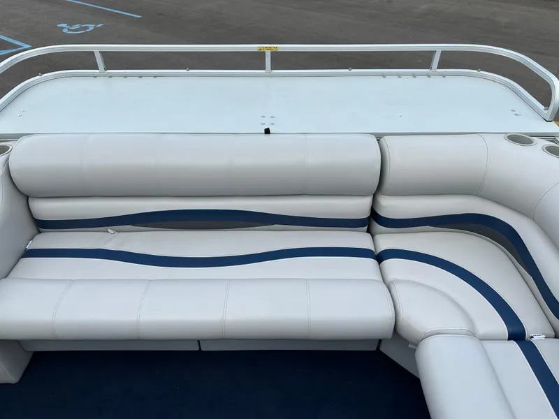 Slide: The Image of White and blue seating on a 1997 Suncruiser 22 boat, featuring cup holders and railing. - 9