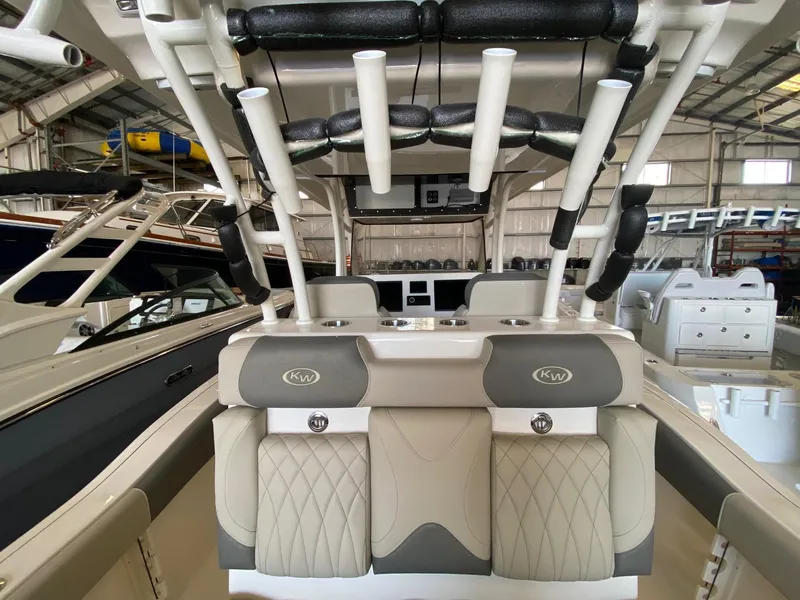 Slide: The Image of 2026 Key West 291 FS boat interior with cushioned seating and rod holders in a showroom. - 11