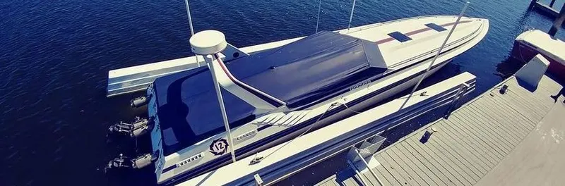 The Image of 1988 Fountain 12 Meter boat docked on calm water, aerial view. - 1
