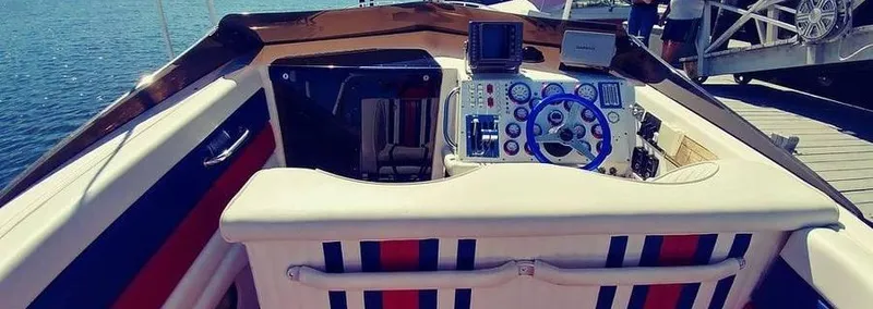 Slide: The Image of Cockpit of a 1988 Fountain 12 Meter boat with nautical controls and striped seating. - 14