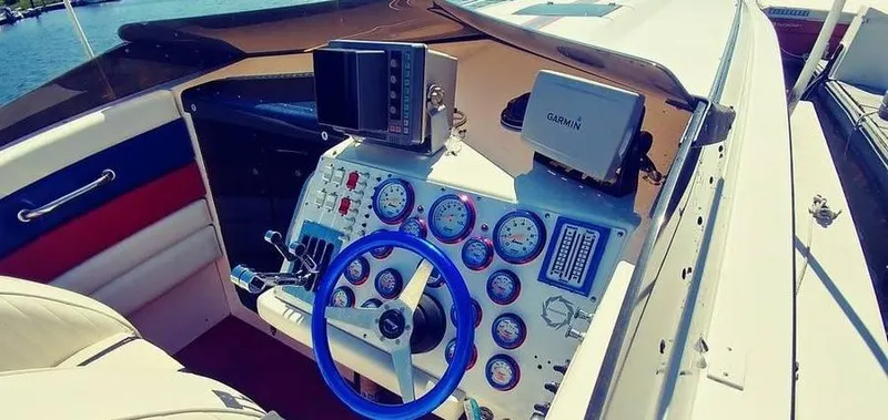 Slide: The Image of Cockpit of a 1988 Fountain 12 Meter boat with blue steering wheel and gauges. - 16