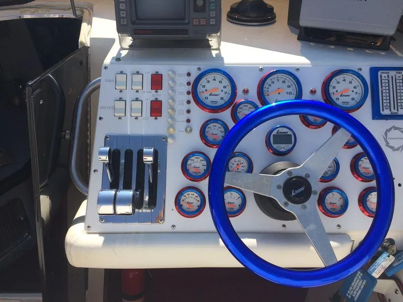 Slide: The Image of Control panel of a 1988 Fountain 12 Meter boat with blue steering wheel and gauges. - 17