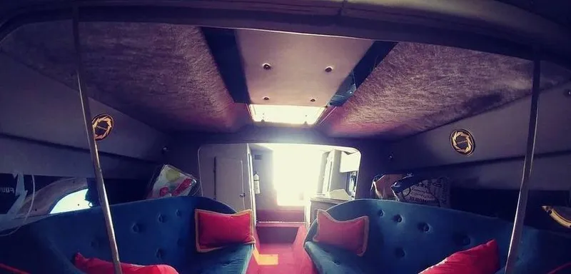 Slide: The Image of Interior of a 1988 Fountain 12 Meter boat with blue seating and red cushions. - 23