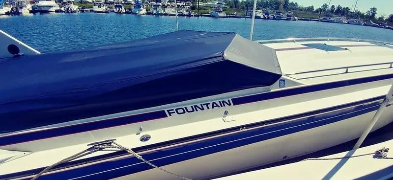 Slide: The Image of 1988 Fountain 12 Meter boat docked at marina, covered and ready for use. - 5