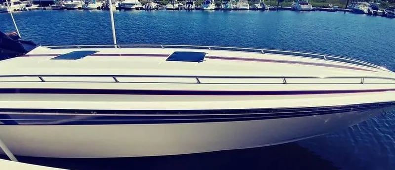 Slide: The Image of 1988 Fountain 12 Meter boat docked in a marina, sleek design, calm water. - 6