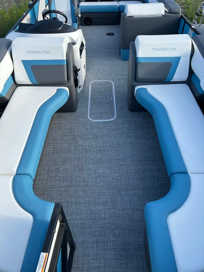 Slide: The Image of 2024 Trifecta 25C SS boat interior with blue and white seating, gray flooring. - 4