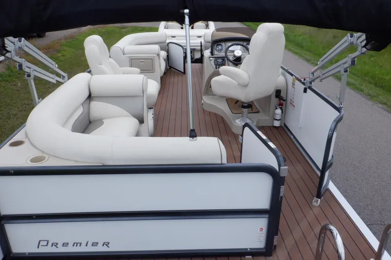 Slide: The Image of 2019 Premier 220 SunSation pontoon boat with white seating and wooden deck. - 2