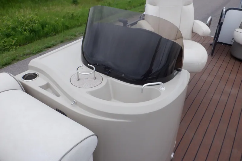 Slide: The Image of 2019 Premier 220 SunSation boat console with windshield and seating on wooden deck. - 28