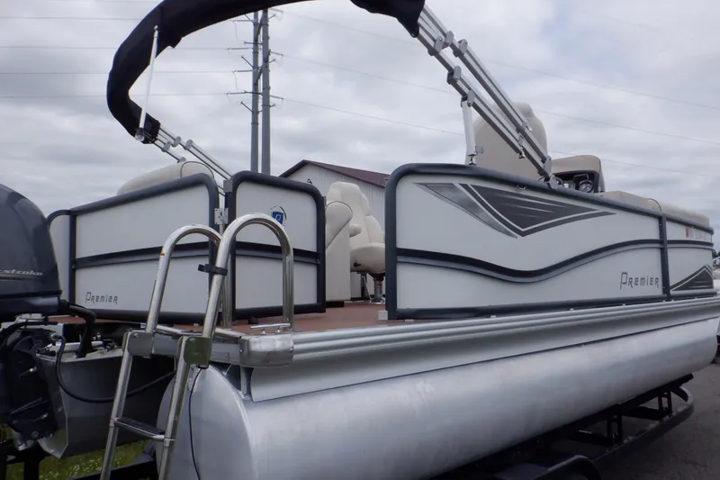 Slide: The Image of 2019 Premier 220 SunSation pontoon boat with seating and canopy, parked outdoors. - 3