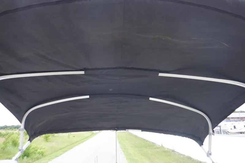 Slide: The Image of 2019 Premier 220 SunSation boat canopy, black fabric with metal frame, outdoor setting. - 46