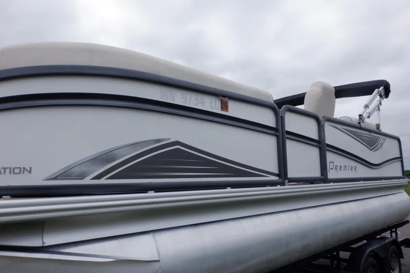 Slide: The Image of 2019 Premier 220 SunSation pontoon boat on trailer under cloudy sky. - 8