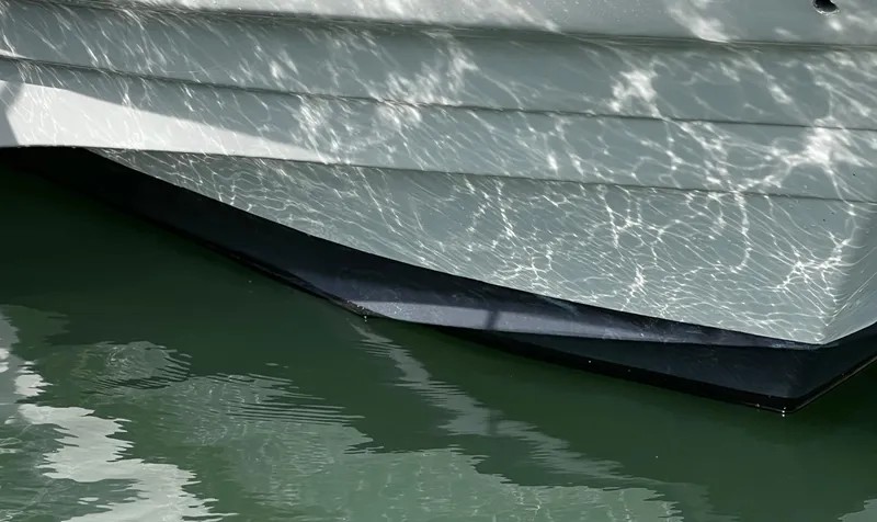 Slide: The Image of 1998 Regal Commodore 2760 boat hull reflecting sunlight on water. - 4