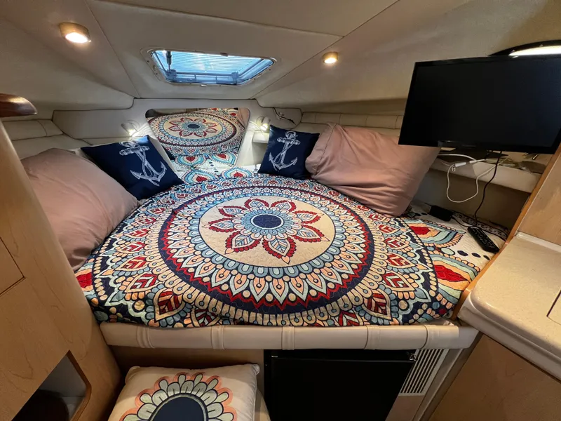 Slide: The Image of Cozy cabin interior of 1998 Regal Commodore 2760 with vibrant mandala bedding and nautical decor. - 5