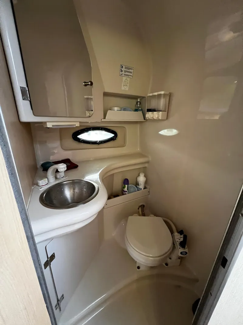 Slide: The Image of 1998 Regal Commodore 2760 boat bathroom with sink, toilet, and storage cabinets. - 7